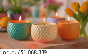 Three candles are placed on a wooden table, creating a simple and elegant display. Стоковое AI-видео, аниматор Данила Большаков / Фотобанк Лори