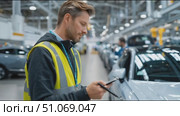 Man in safety vest conducts vehicle inspection at manufacturing facility. Стоковое AI-видео, аниматор Сергей Толмачёв / Фотобанк Лори