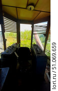 Abandoned control room of a train surrounded by overgrown vegetation in a rural area during daylight hours. Стоковое фото, фотограф Александра Рублева / Фотобанк Лори