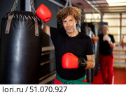 Strong man practicing punches on punching bag. Boxing training. Стоковое фото, фотограф Яков Филимонов / Фотобанк Лори
