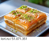 Delicious baklava dessert with nuts and honey served on a silver plate. Стоковое AI-изображение, AI-художник Татьяна  Бральнина / Фотобанк Лори
