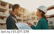 Two professionals discuss project plans while overseeing a construction site at sunset. Стоковое AI-видео, аниматор Данила Большаков / Фотобанк Лори
