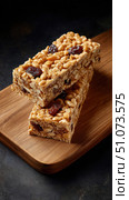 Two puffed rice bars with raisins resting on wooden board. Стоковое AI-изображение, AI-художник Юрий Поздников / Фотобанк Лори