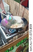 A man cooks a secret food Pad Thai in a wok on the street, tossing and turning the noodles and bean sprouts. Mobile vertical video. Thailand, Pattaya. Редакционное видео, видеограф Коханова Наталья / Фотобанк Лори
