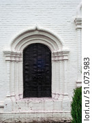 Gorokhovets, Russia - 07.20.2025. Ornate Black Iron Door on White Brick Wall in Sretensky Monastery. Стоковое фото, фотограф Ольга Губская / Фотобанк Лори