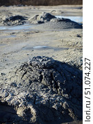 A mud volcano and a stream of grey clay from an eruption and gas escape. Cracked soil surface. Texture of a mudflow. Стоковое фото, фотограф Наталия Кирсанова / Фотобанк Лори