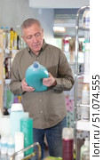 Man consumer with household chemical products for washing indoors. Стоковое видео, видеограф Яков Филимонов / Фотобанк Лори