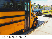 Close-up view of a bright yellow school bus parked along a city street under a sunny sky. Стоковое фото, фотограф Виктор Ветошкин / Фотобанк Лори