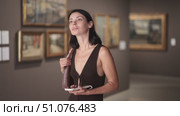 University student visits a museum and an exhibition to prepare for her diploma, she holds mobile phone in hands and uses an online guide. Стоковое видео, видеограф Яков Филимонов / Фотобанк Лори