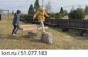 Kids engaging in outdoor fun at the park, running around and playing games on a bright summer day during school holidays. Стоковое видео, видеограф Ирина Старикова / Фотобанк Лори