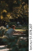 Man thinks deeply while playing chess alone in a serene park setting on a sunny day. Стоковое AI-видео, аниматор Сергей Толмачёв / Фотобанк Лори