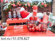Krasnodar, Russia - December 10, 2021: Various cans or bottles of Coca-Cola on the street during the snow. Редакционное фото, фотограф Наталия Кирсанова / Фотобанк Лори