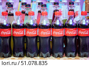 KRASNODAR, Russia - September 15, 2022: Glass bottles with Coca-Cola drink are on the table with other drinks. Редакционное фото, фотограф Наталия Кирсанова / Фотобанк Лори