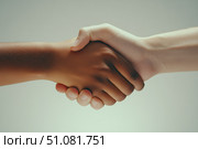 A cinematic close-up of two diverse hands clasping in a firm handshake. This high-contrast image symbolizes trust and partnership, highlighting cooperation and mutual respect between different cultures. Стоковое AI-изображение, AI-художник Nart / Фотобанк Лори