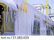 Large ice icicles hang from the roof of the production facility. Security concept. Стоковое фото, фотограф lyudmila Soloveva / Фотобанк Лори
