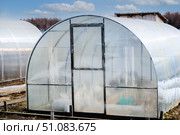 A small greenhouse with a metal frame covered with polycarbonate for growing vegetables. Стоковое фото, фотограф lyudmila Soloveva / Фотобанк Лори