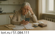 An elderly Caucasian woman with gray hair sits at a table, looking stressed while holding a smartphone. Papers and a wallet are scattered around her. Стоковое AI-видео, аниматор Nart / Фотобанк Лори