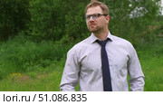 Confident Businessman in Natural Setting. Man stands in front of lush green backdrop. Remote working. Portrait of happy mid adult male wearing formal clothes, shirt and tie, glasses. Find inspiration. Стоковое видео, видеограф Марина Демидюк / Фотобанк Лори