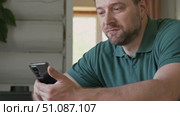 Man using his cellphone. Handsome guy use mobile phone at home. Male browses social networks, gaming, does shopping online, chats with friends, writes or reads messages. Close up. 4k video footage. Стоковое видео, видеограф Марина Демидюк / Фотобанк Лори
