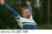 Young man stands with her arms outstretched to the side in the green park. Feeling free outdoor. Winning life achievement, freedom goal concept. Guy business employer, manager inspired in nature. Стоковое видео, видеограф Марина Демидюк / Фотобанк Лори