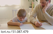 Dad teaches his son writing and counting. Kids primary education. Children learn, study in home school. Daddy male helping teaching little child boy support studying, learning homework. Knowledge day. Стоковое видео, видеограф Марина Демидюк / Фотобанк Лори