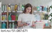 Girl looking for trademark sign on label, chooses eco friendly razor kit. Стоковое видео, видеограф Яков Филимонов / Фотобанк Лори