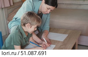 Mom education son writing. Kids learn and study in home school. Mommy female helping teaching little boy support studying, learning homework. Child care teach study. Knowledge day. Children schooling. Стоковое видео, видеограф Марина Демидюк / Фотобанк Лори