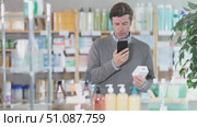 In drug store, man examine body lotion packaging, buy product. Стоковое видео, видеограф Яков Филимонов / Фотобанк Лори