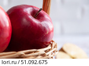 Fresh red apples in a wicker basket. Apples close-up with a cut slice. Wicker old basket with fruit. Selective focus. Стоковое фото, фотограф Анастасия  Гудантова / Фотобанк Лори