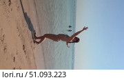 A 50-year-old European woman in a swimsuit walks along the beach in Doha, Qatar. Стоковое видео, видеограф IRYNA ZAKHARANKA / Фотобанк Лори