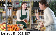 Woman seller in apron serves girl customer, demonstrates various versions of nougat. Стоковое видео, видеограф Яков Филимонов / Фотобанк Лори