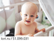 Innocence Radiates From Baby's Bright Eyes, Playing in Crib. Стоковое фото, фотограф Aleksandr Golubev / Фотобанк Лори