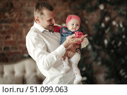 Daddy's Darling Holds His Baby Girl in a Bright, Cozy Indoor Space. Стоковое фото, фотограф Aleksandr Golubev / Фотобанк Лори