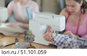 Close-up of woman seamstress sews on sewing machine. Стоковое видео, видеограф Яков Филимонов / Фотобанк Лори