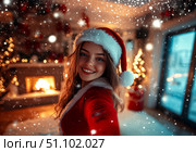 Festive woman in santa hat taking selfie in cozy christmas setting. Стоковое AI-изображение, AI-художник Сергей Бирюков / Фотобанк Лори