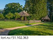 View of the traditional log Russian houses in the Mikhailovskoye estate of the Pushkin Museum-Reserve on a sunny summer day, Pushkinskiye Gory, Pskov region, Russia. Стоковое фото, фотограф Ula Ulachka / Фотобанк Лори