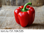Fresh red bell pepper sitting on rustic burlap surface. Стоковое AI-изображение, AI-художник Иван Рябоконь / Фотобанк Лори