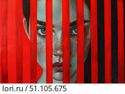 Woman hiding behind red lines conveys mystery and intrigue. Стоковое AI-изображение, AI-художник Иван Рябоконь / Фотобанк Лори