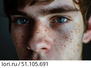 Teen boy showing ephelides on face and light eyes is looking at camera. Стоковое AI-изображение, AI-художник Иван Рябоконь / Фотобанк Лори