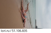 A 50-year-old European woman in a swimsuit walks along the beach in Doha, Qatar. Стоковое видео, видеограф IRYNA ZAKHARANKA / Фотобанк Лори