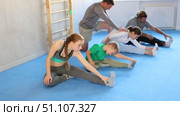 Parents with children family perform warm-up exercises and legs stretching. Стоковое видео, видеограф Яков Филимонов / Фотобанк Лори