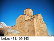 Stepantsminda, Georgia - January 03, 2023: Gergeti Church of the 14th century at the foot of Mount Kazbek. Редакционное фото, фотограф Наталия Кирсанова / Фотобанк Лори
