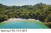 Secluded tropical beach with people swimming and relaxing near sea water. Стоковое видео, видеограф Ольга Сухарева / Фотобанк Лори