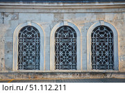 The facade of the building with antique windows and openwork grilles. Стоковое фото, фотограф Наталия Кирсанова / Фотобанк Лори