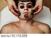 Gentle Hands Placing Hot Stones During a Facial Massage for Ultimate Relaxation. Стоковое фото, фотограф Aleksandr Golubev / Фотобанк Лори