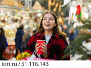 Happy girl with paper cup of coffee walking in Christmas fair. Стоковое фото, фотограф Яков Филимонов / Фотобанк Лори