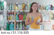 Young woman choosing sunscreen in household chemicals store. Стоковое видео, видеограф Яков Филимонов / Фотобанк Лори