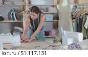 Female fashion designer drafting clothing pattern on paper in studio. Стоковое видео, видеограф Яков Филимонов / Фотобанк Лори