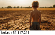 A young child stands in a landscape that has been ravaged by drought, beneath a sky full of dramatic clouds. Стоковое AI-изображение, AI-художник Anastasy Yarmolovich / Фотобанк Лори