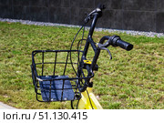 Black basket on a yellow bike handlebar for various activities. Стоковое фото, фотограф Аксенова Вера / Фотобанк Лори